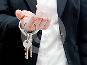 A real estate agent holding keys to a new house in her hands.