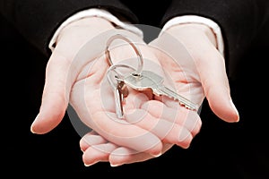 A real estate agent holding keys to a new house in her hands.