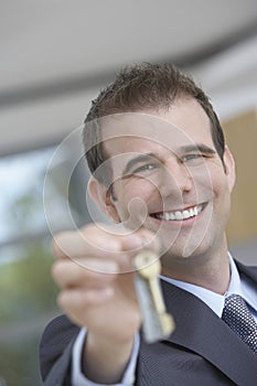 Real Estate Agent Holding Out House Key