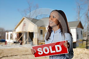 Real Estate Agent holding a sold sign