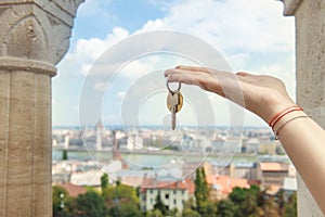 Real estate agent with house keys and European cityscape