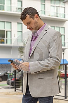 The real estate agent looks at his smartphone facing profile