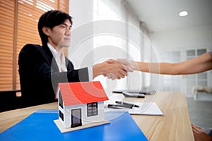 Real estate agent man and customer woman handshake together after agreement success about credit house and insurance.