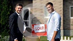 Real estate agent and new apartment owner smiling at camera, good deal, ad