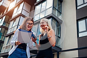 Real estate agent presenting new apartment to client. Businesswoman shows contract to customer. Partners laughing