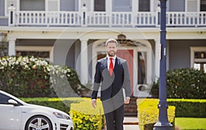 Real estate. Agent ready to sell home. Businessman standing outside a modern house.