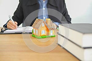 real estate agent realtor writing note with house model. buying