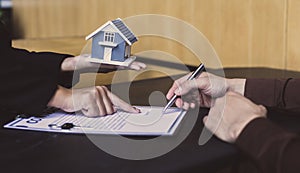 Real estate agent or sales manager has proposed terms and conditions to customers who sign house purchase agreements with insuranc photo