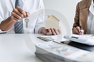 Real estate agent Sales manager holding filing keys to customer after signing rental lease contract of sale purchase agreement,