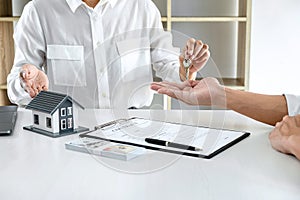 Real estate agent Sales manager holding filing keys to customer after signing rental lease contract of sale purchase agreement,