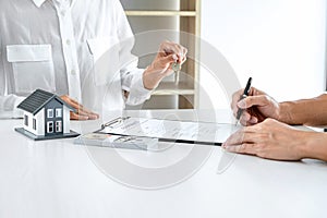 Real estate agent Sales manager holding filing keys to customer after signing rental lease contract of sale purchase agreement,