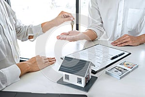 Real estate agent Sales manager holding filing keys to customer after signing rental lease contract of sale purchase agreement,