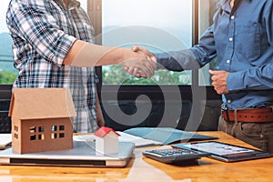 Real estate agent shaking hands with his client after sealing deal