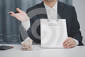 Real estate agent showing contract agreement at office. Home sales and home insurance concept.