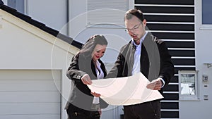 A real estate agent showing a customer house plan