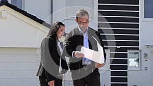 A real estate agent showing a customer house plan