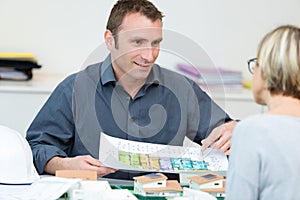 real estate agent showing floor plan to client