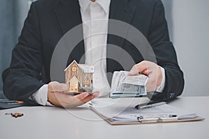 Real estate agent showing house model at office. Home sales and home insurance concept.