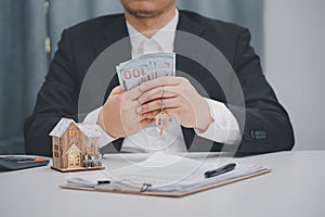 Real estate agent showing house model at office. Home sales and home insurance concept.