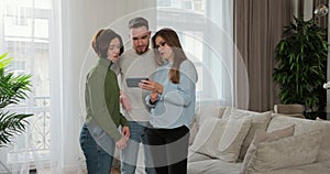 Real estate agent is showing house plan on tablet talking to customers young family using modern technology. Home buying