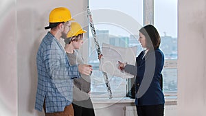 A real estate agent showing a layout to a young married couple