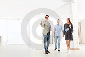 Real estate agent showing new apartment to young couple.