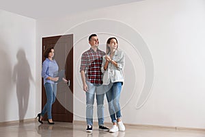 Real estate agent showing new apartment to young couple.