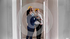 A real estate agent showing a new draft apartment to a family - looking up