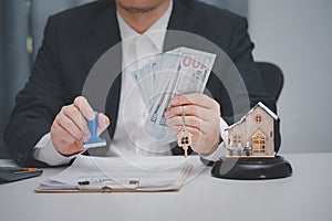 Real estate agent stamping approved loan document at office. Real estate, home loan and investments concept.