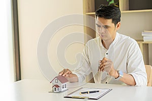 A real estate agent who explains home styles to clients with home design perspectives and purchase contracts and insurance concept
