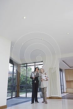 Real Estate Agent And Woman Observing New Property photo
