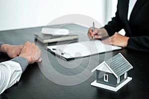 Real estate agent working sign agreement document contract for home loan insurance approving purchases for client with house model