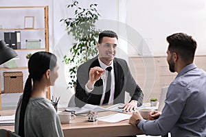 Real estate agent working with young couple in office. Mortgage concept