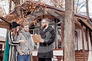 Real-estate agent with young caucasian happy couple buying new house