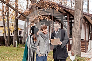 Real-estate agent with young caucasian happy couple buying new house