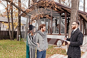 Real-estate agent with young caucasian happy couple buying new house