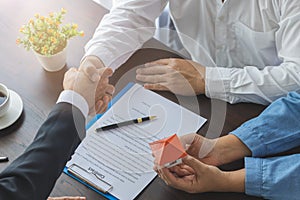 Real estate agents and customers shake hands to congratulate after signing a contract to buy a house with land and insurance, Home