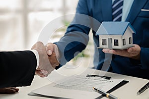 Real estate agents explain models of housing estates in projects to elaborate to clients, explaining and presenting information