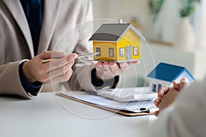 Real estate agents explain models of housing estates in projects to elaborate to clients, explaining and presenting information