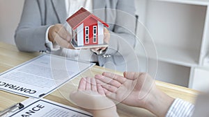 Real estate agents or sales managers hand over homes to customers who have signed home purchases with insurance