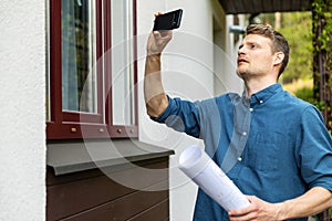 Real estate appraiser taking pictures of property with phone