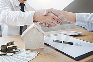 Real estate broker agent and customer shaking hands after signin