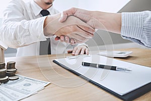 Real estate broker agent and customer shaking hands after signing contract documents for ownership realty purchase, Concept