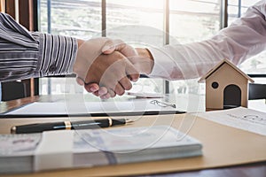 Real estate broker agent and customer shaking hands after signing contract documents for realty purchase, Bank employees