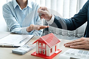 Real estate broker agent holding filing keys to the customer after signing rental lease contract of the sale purchase agreement