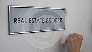 Real estate broker office door, hand knocking closeup, apartment purchase deal