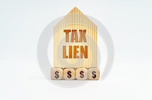 On a white surface stands a wooden model of a house with the inscription - Tax lien photo