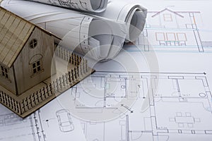 Real Estate concept. Architect workplace. Architectural project, blueprints, blueprint rolls and model house on plans