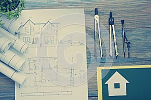 Real Estate concept. Architectural project, blueprints, blueprint rolls and divider compass on vintage wooden table