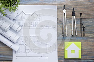 Real Estate concept. Architectural project, blueprints, blueprint rolls and divider compass on vintage wooden table